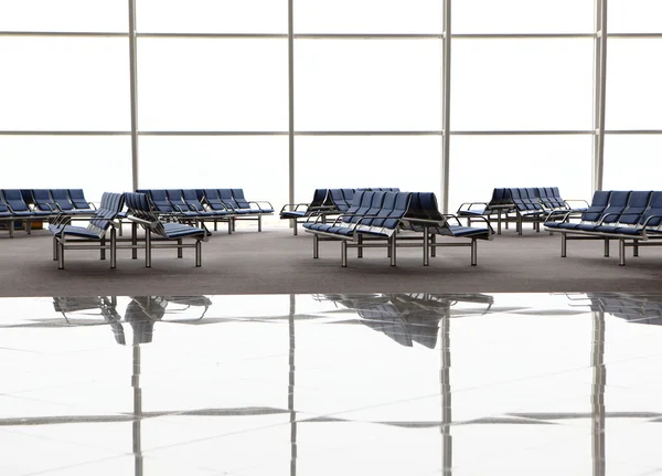 Reflektion av väntrum med blå stolar och fönster på flygplat — Stockfoto