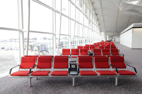 香港の空港で赤い椅子行μπουκέτο αγριολούλουδα — ストック写真