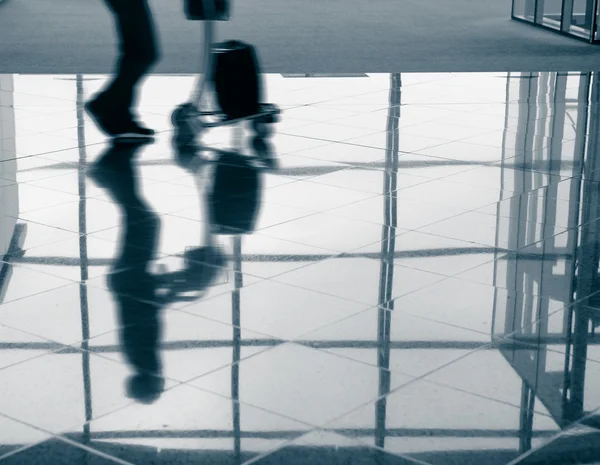 Пассажир (мужчина) мчится через терминал аэропорта голубым тоном — стоковое фото