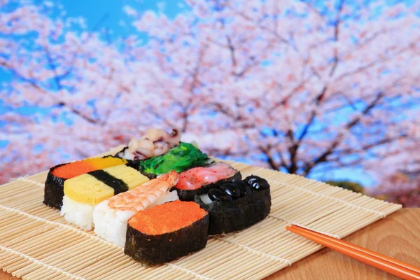 Sabroso sushi japón con flores de cerezo rosa —  Fotos de Stock