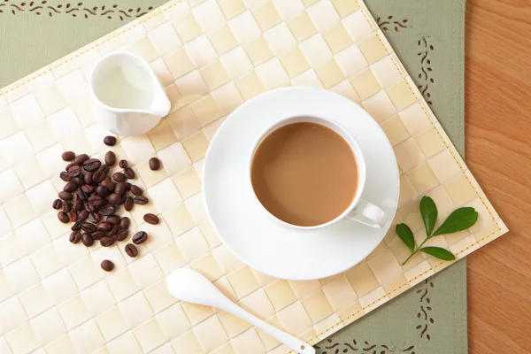 Zrnko kávy a horkou kávu s zelený list — Stock fotografie