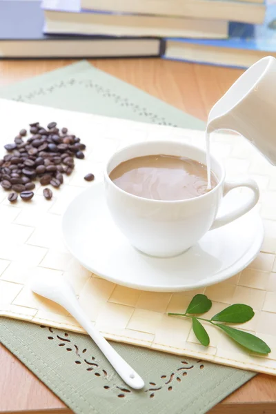 Coffee bean and hot coffee with green leaf — Stock Photo, Image