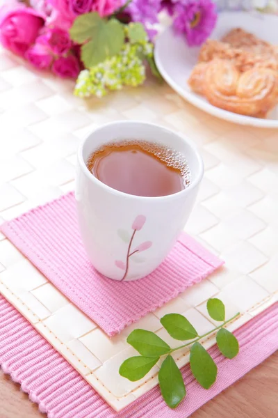 Φλιτζάνι μαύρο τσάι με μπισκότο και πανέμορφα λουλούδια — Φωτογραφία Αρχείου