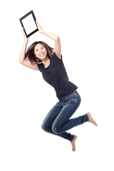 Jovem beleza feliz salto e mostrando tablet pc no ar — Fotografia de Stock
