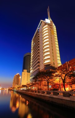 Business Building with Sunset and reflection of river clipart