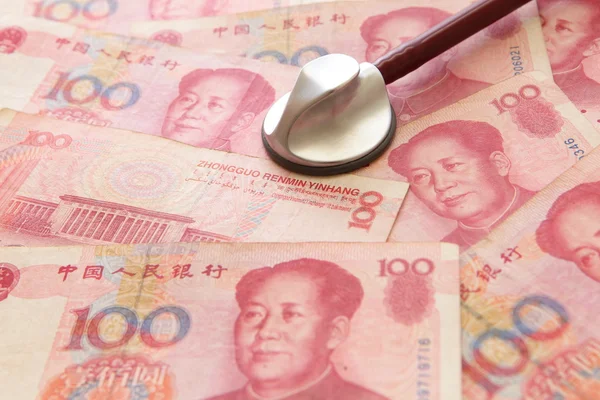 Luister naar chinese geld yuan door stethoscoop — Stockfoto