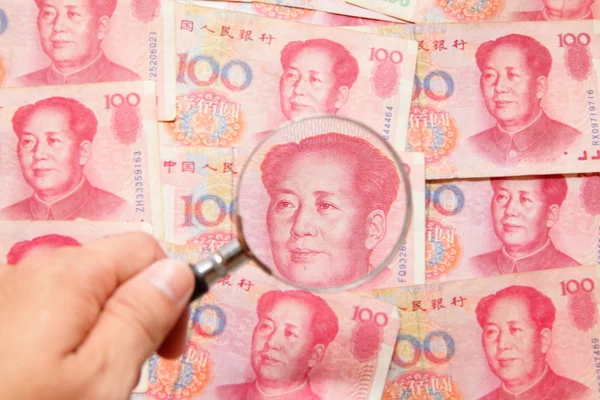 Dinheiro chinês (moeda) e lupa — Fotografia de Stock