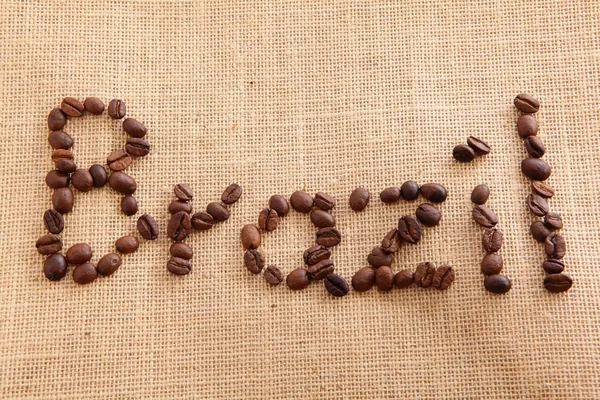 Chicchi di caffè su sfondo lino (Brasile Simbolo di testo ) — Foto Stock