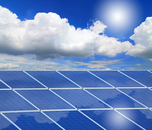 Панелі сонячних батарей з відображенням, Синє небо, білі хмари та сонце — стокове фото