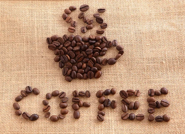 Chicchi di caffè su sfondo lino — Foto Stock