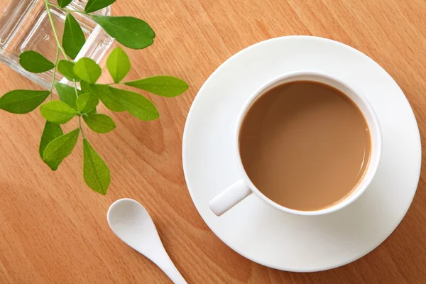 Latte καφέ σε ένα λευκό φλιτζάνι με πράσινο φύλλο — Φωτογραφία Αρχείου