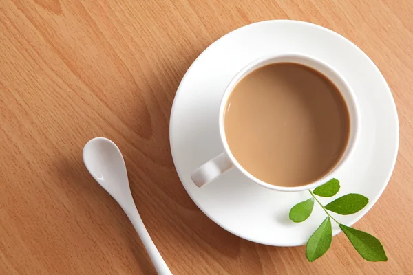 Латте кофе в белой чашке с зеленым листом — стоковое фото