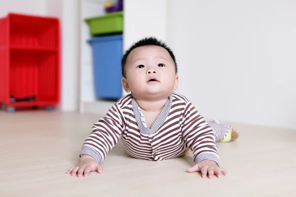 Bebê bonito rastejando no chão da sala de estar — Fotografia de Stock