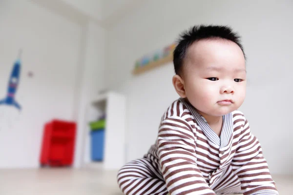 Fechar o rosto sério do bebê com backgroung em casa — Fotografia de Stock
