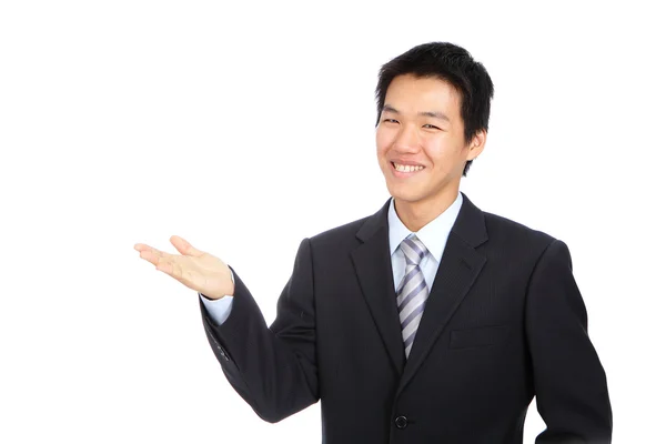 Jovem homem de negócios sorrir e mostrando apresentar gesto de mão — Fotografia de Stock