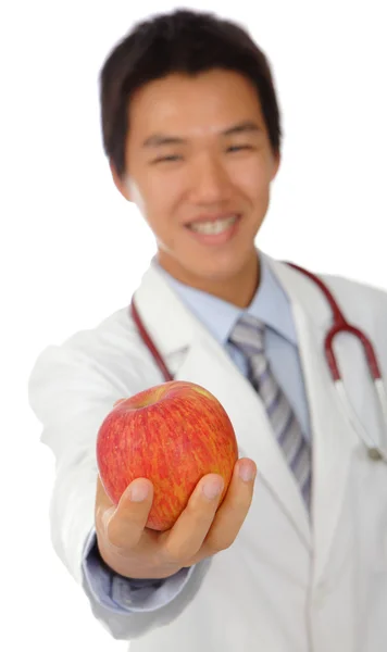 Młody lekarz trzyma jabłko — Zdjęcie stockowe