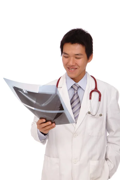 Молодий азіатський лікар серйозно перевіряє рентгенівський знімок — стокове фото