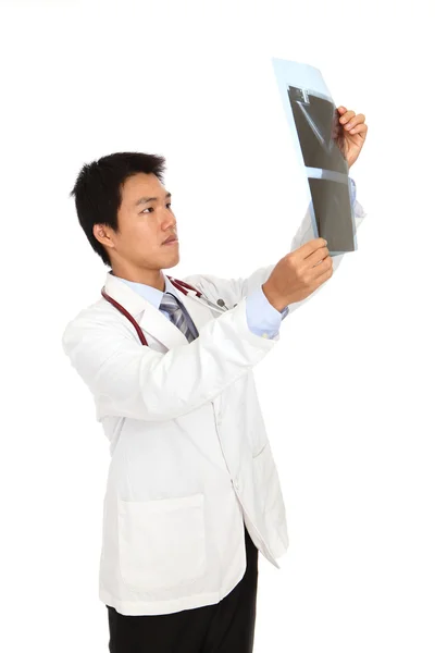 El médico joven revisa cuidadosamente los rayos X — Foto de Stock