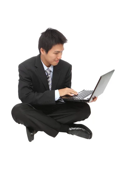 Junger Geschäftsmann sitzt und benutzt ein Notizbuch — Stockfoto