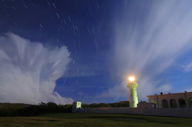 Lighthouse in the night with moving star and floating cloud clipart