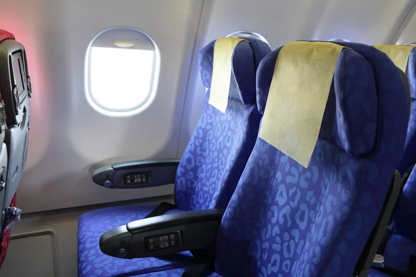 Vliegtuig blauwe stoel en venster binnen een vliegtuig — Stockfoto