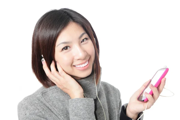Joven chica feliz escuchar música con auriculares por teléfono móvil —  Fotos de Stock