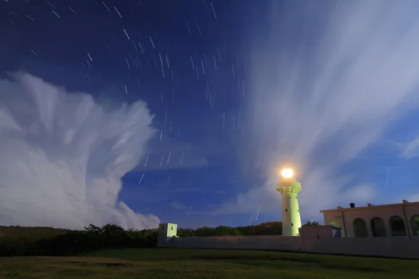 Lighthouse in the night with moving star and floating cloud — Stock Photo, Image