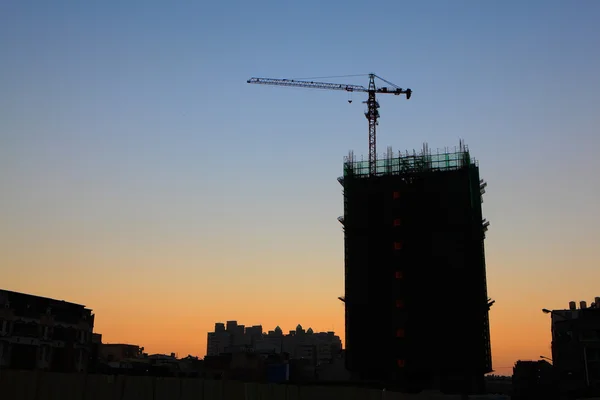 Stavební jeřáby silueta se západem slunce — Stock fotografie