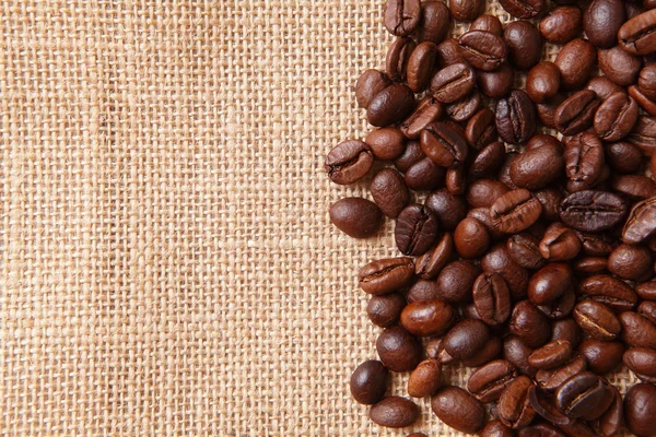 Kávová zrna na lněné pozadí — Stock fotografie