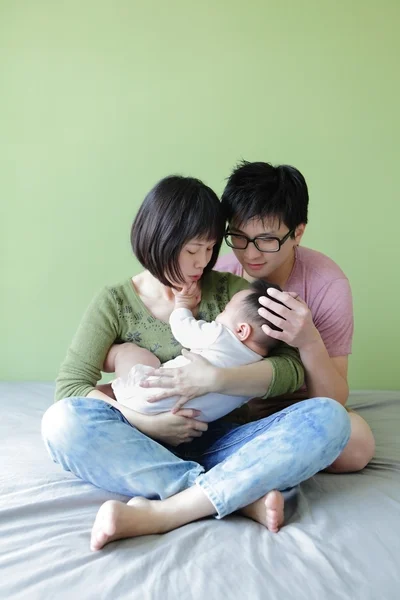 Junge Eltern schauen auf ihr Baby — Stockfoto