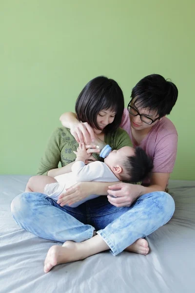 Мати і батько годують дитину пляшкою — стокове фото