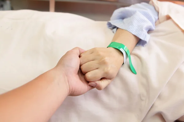 Man greppar sin hustrus hand före operation — Stockfoto