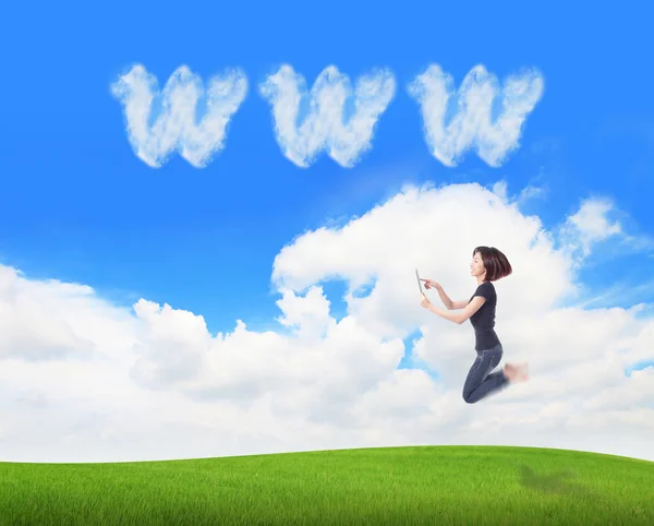 Mädchen springen und Tablet-PC mit WWW-Cloud nutzen — Stockfoto