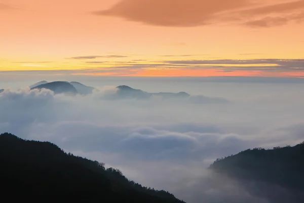 Dramatyczne chmury toczenia w górach na zachodzie słońca — Zdjęcie stockowe