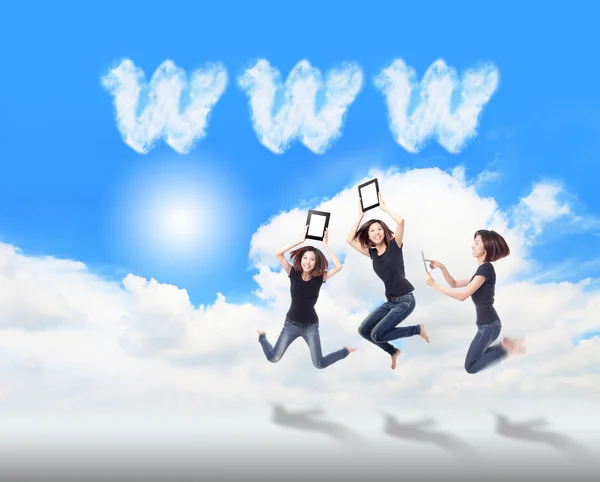 Glückliche Mädchen springen und spielen Tablet-PC in der Luft — Stockfoto
