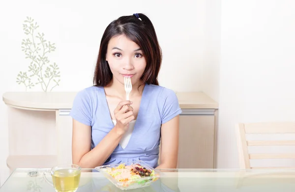 Gelukkig lachende vrouw met salade thuis — Stockfoto