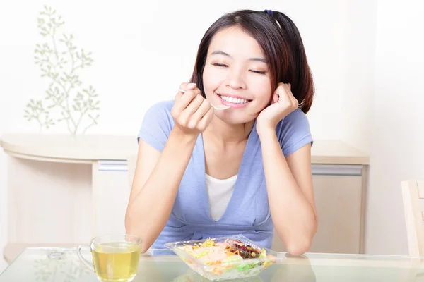 Щаслива усміхнена жінка з салатом вдома — стокове фото