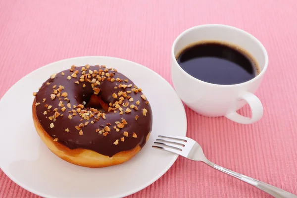 Donut de chocolate com uma xícara de café — Fotografia de Stock
