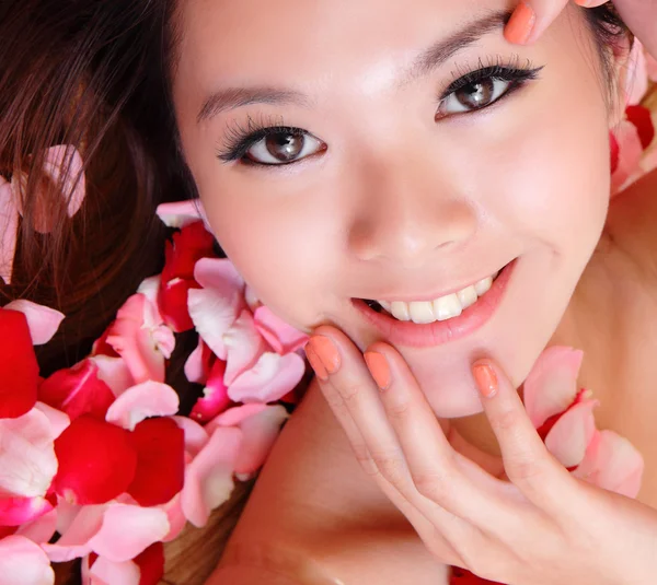 Menina sorrindo e toque rosto com rosa vermelha — Fotografia de Stock