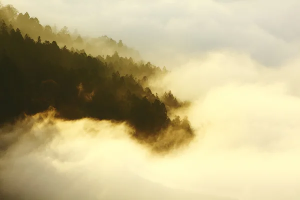 Nuvens dramáticas rolando sobre montanhas ao pôr do sol — Fotografia de Stock