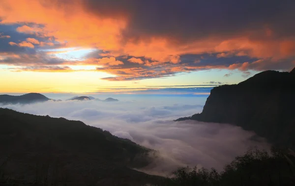 Dramatische Wolken wälzen sich bei Sonnenuntergang über die Berge — Stockfoto