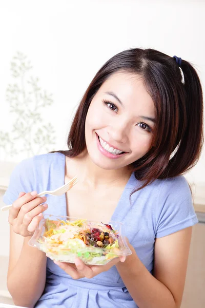 Menina feliz comer salada em casa — Fotografia de Stock