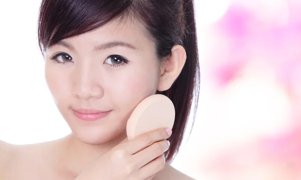 Mulher aplicando fundação no rosto com esponja cosmética — Fotografia de Stock
