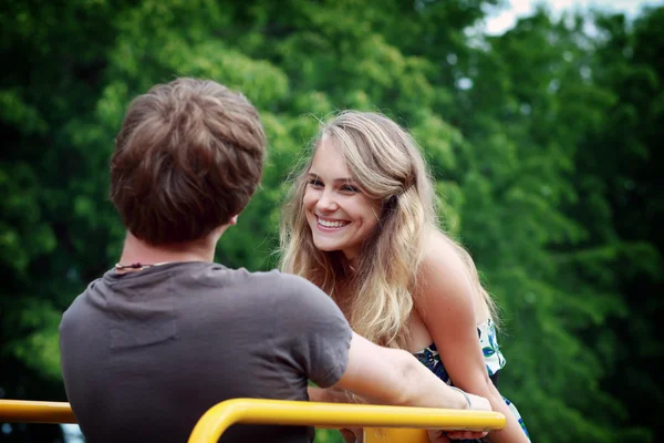 Jovem feliz homem e mulher apaixonados estão olhando e sorrindo um para o outro em Imagem De Stock