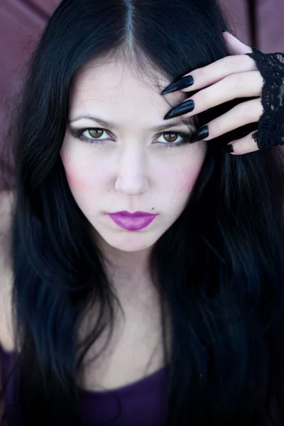 Retrato de close-up de uma linda garota gótica segurando a mão perto do rosto — Fotografia de Stock