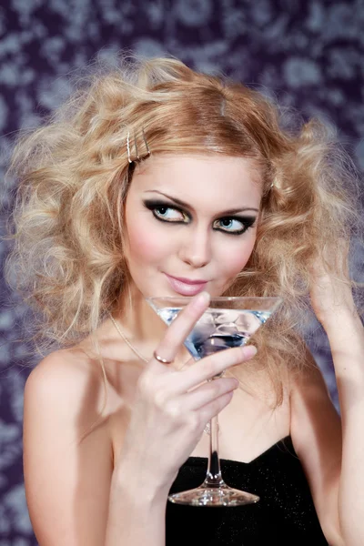 Vacker blond ung kvinna med blå cocktail på en blommig bakgrund — Stockfoto