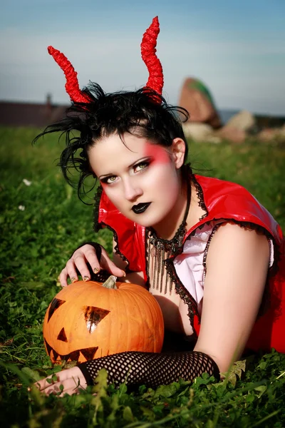 Beautiful gothic female holding a halloween pumpkin — Stock Photo, Image
