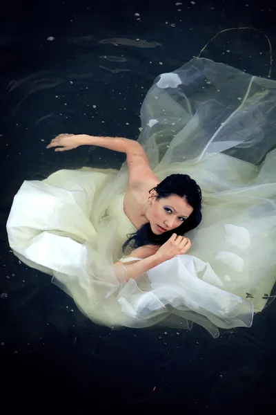 휴지통 드레스입니다. 신부는 수영에 하고있다 그녀의 웨딩 드레스 로열티 프리 스톡 이미지