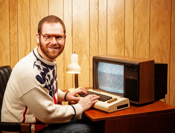 Knappe nerdy volwassene met behulp van een vintage computer tv — Stockfoto