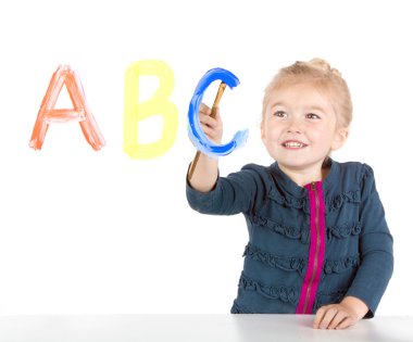 Little girl paints letters on window clipart